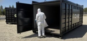 cve worker trowing out asbestos in a cve branded dumpster